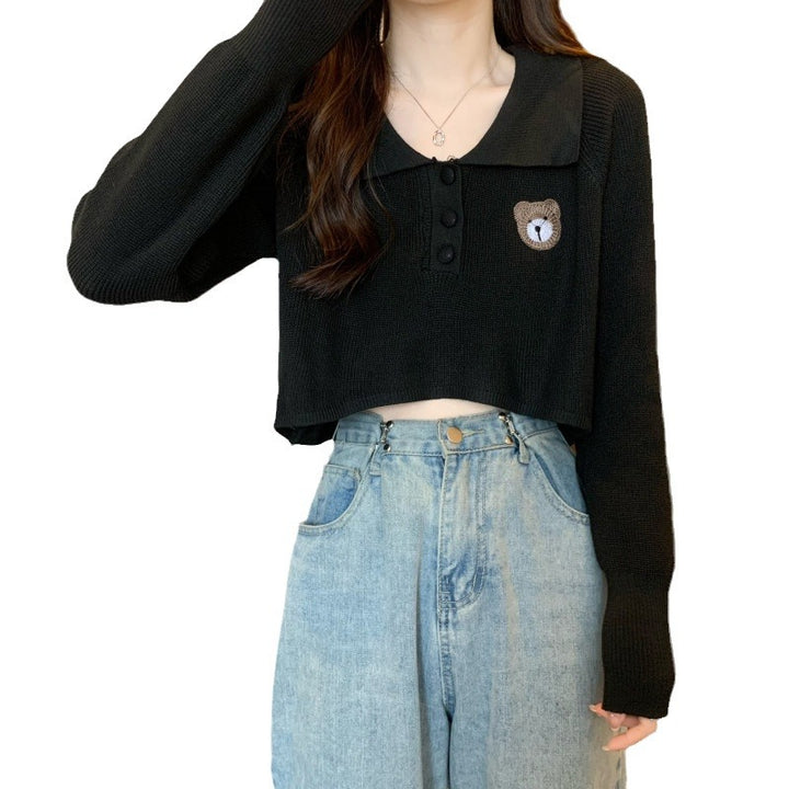 Kvinne cropped genser med en knapp lukking og unicorn emblem