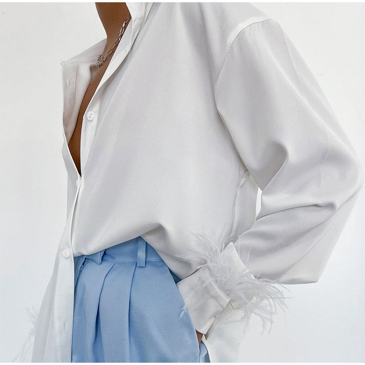 Damebluse med fargerike fjær og elegant snitt Skjora