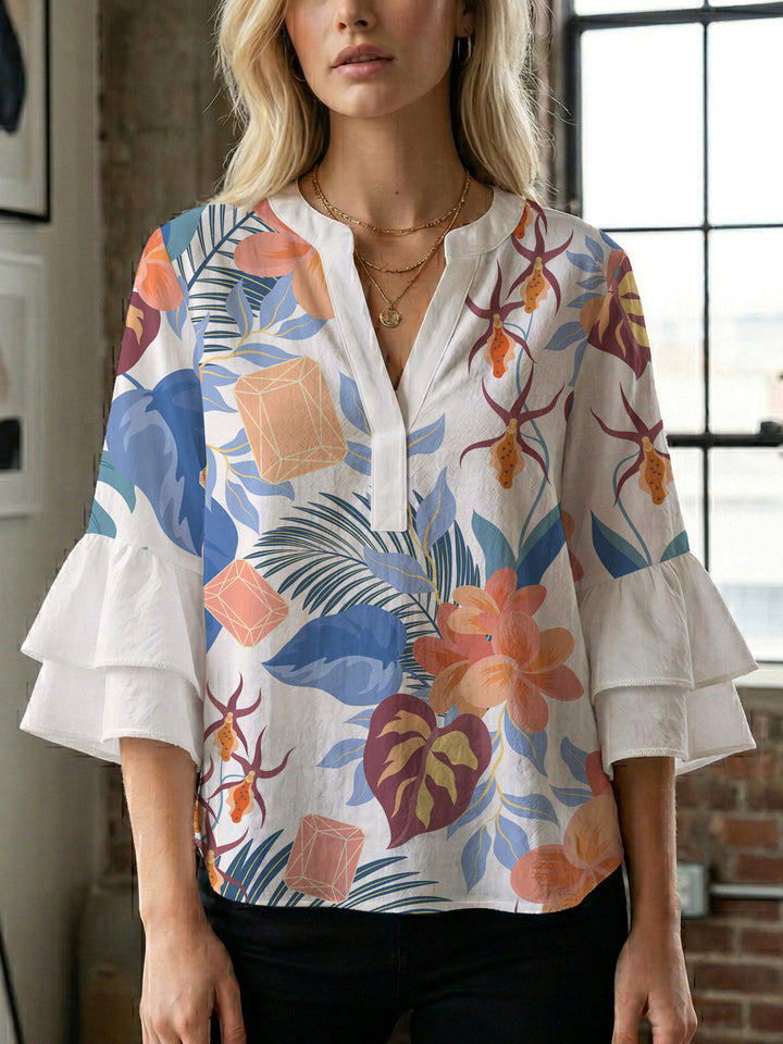 Damebluse med voluminøse volangermer og floral trykk Skjora