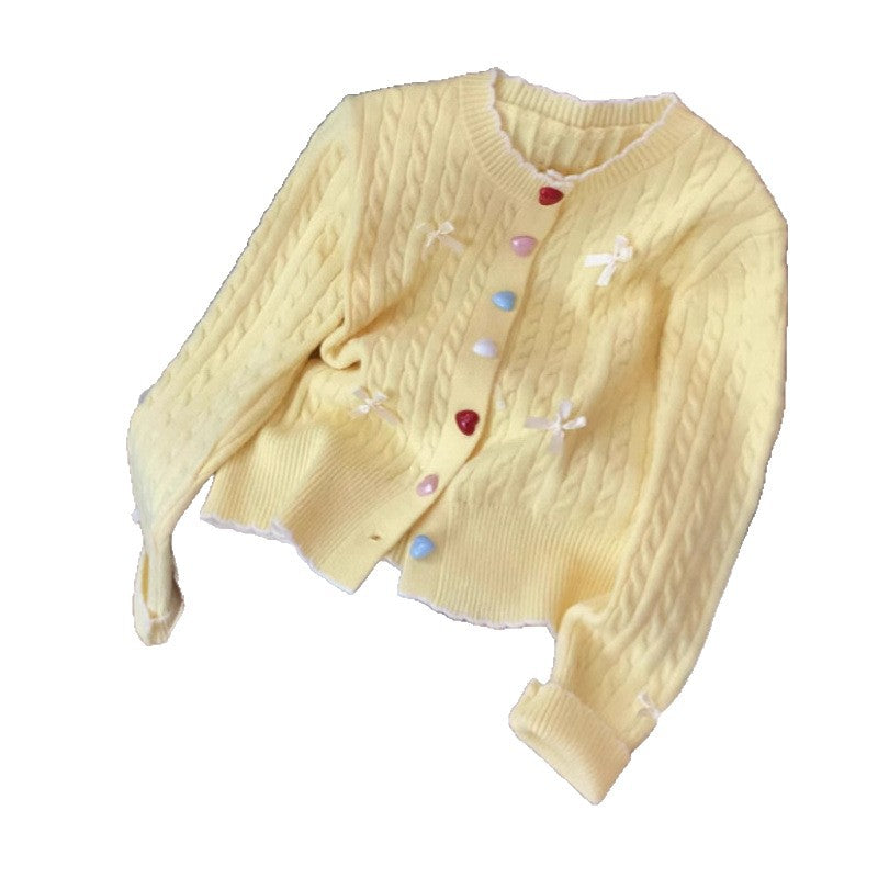 Kvinnens chunky strikket cardigan med lekne knappdetaljer og sløyfer