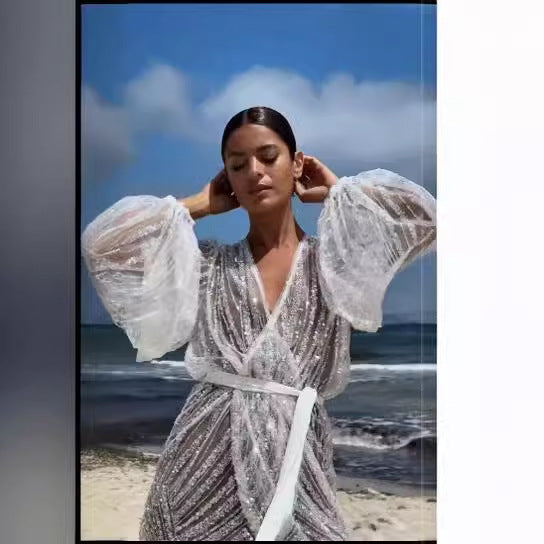 Kvinnens glitrende strandkåpe med elegant belte og brede utvidede ermer Skjora