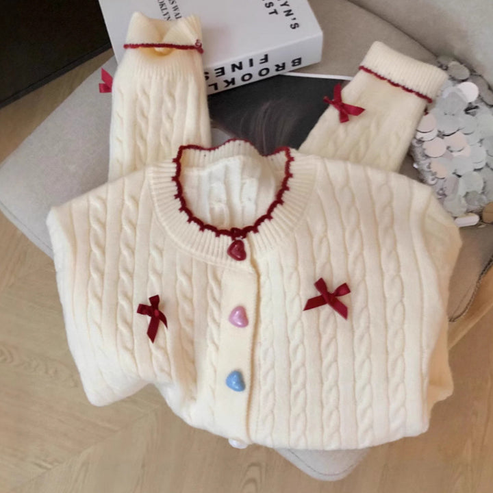 Kvinnens chunky strikket cardigan med lekne knappdetaljer og sløyfer