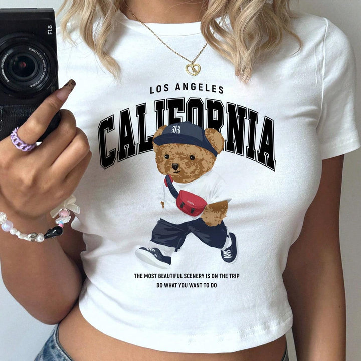 Dame Crop-T-shirt med lekent bjørnemotiv og moderne skrift Skjora