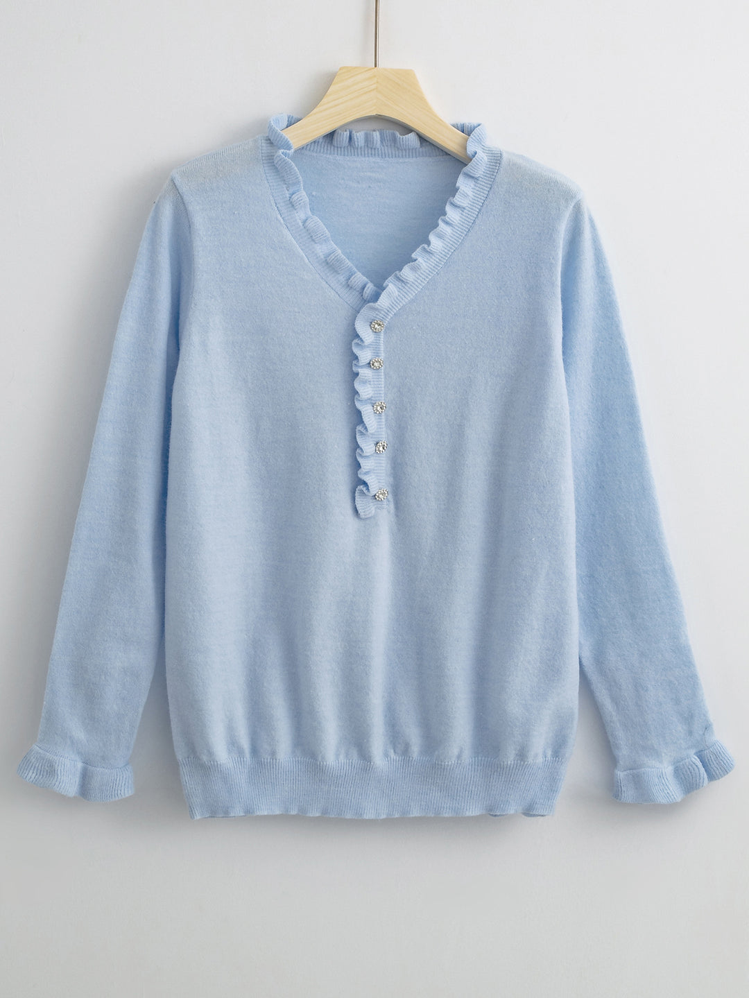 Damebluse med flytende volangdesign og knapplisting Skjora