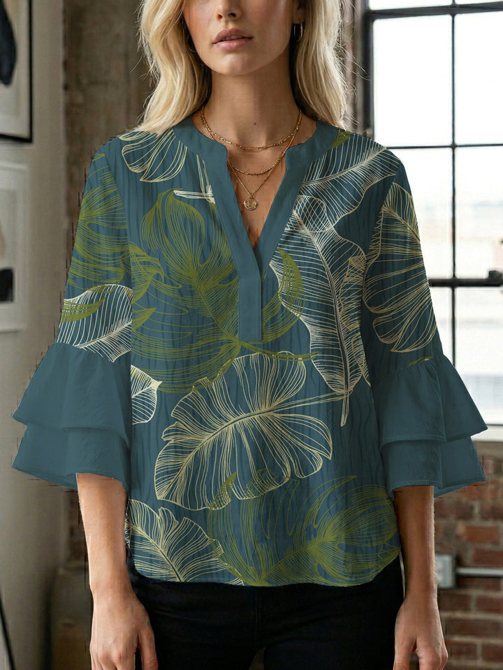 Damebluse med voluminøse volangermer og floral trykk Skjora