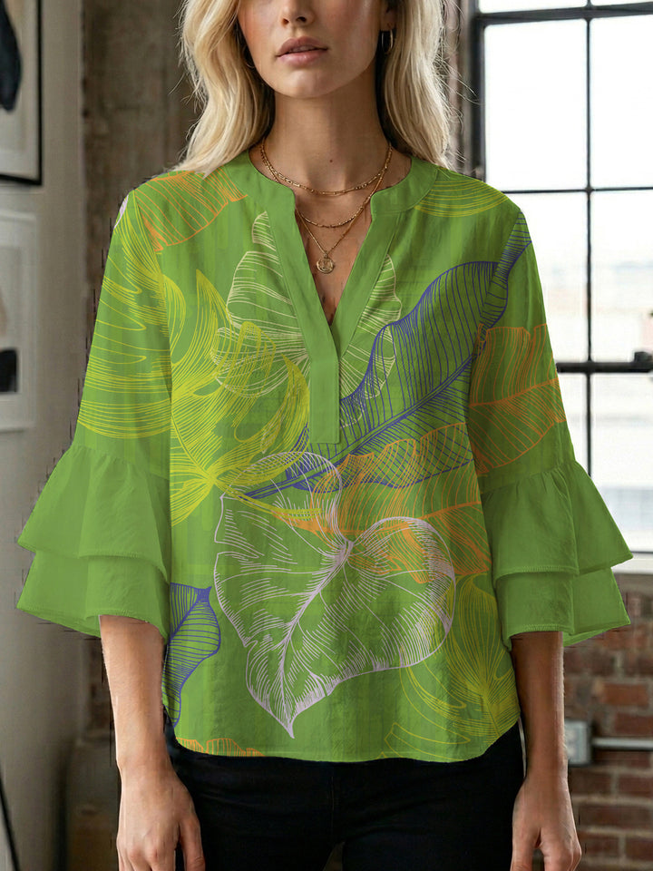 Damebluse med voluminøse volangermer og floral trykk Skjora