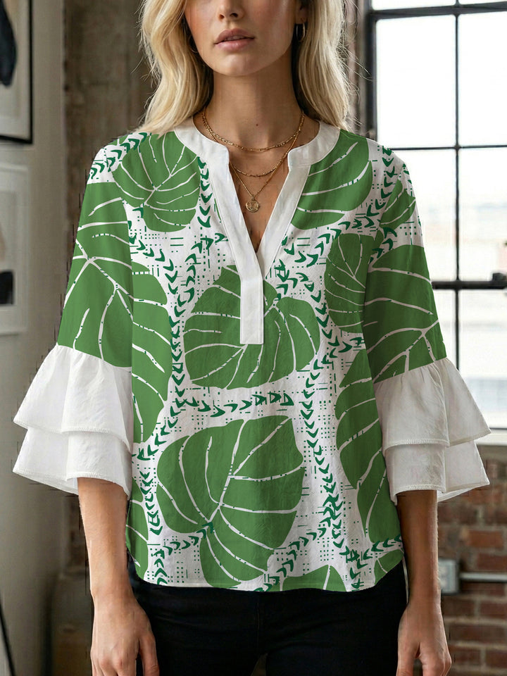 Damebluse med voluminøse volangermer og floral trykk Skjora
