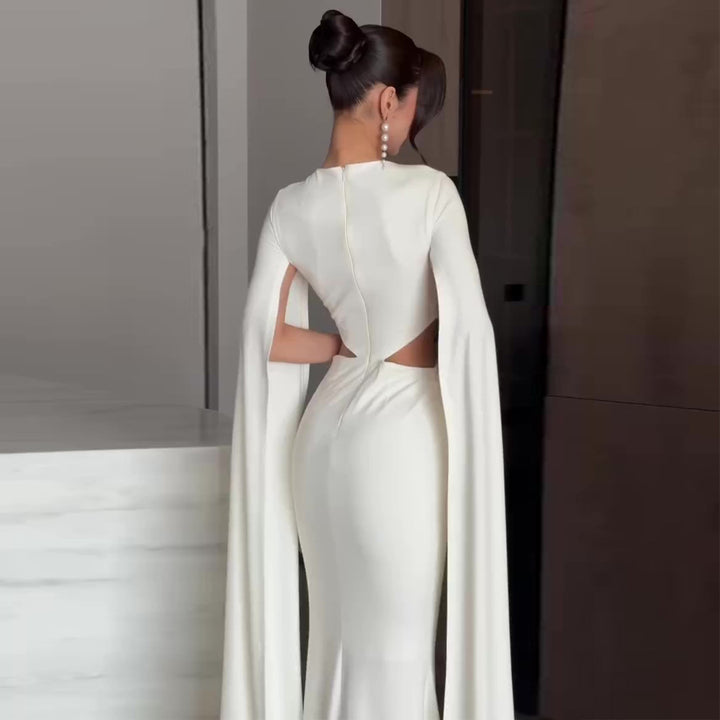Kvinnens elegante kveldskjole med innovativt cut-out og dramatisk kappe