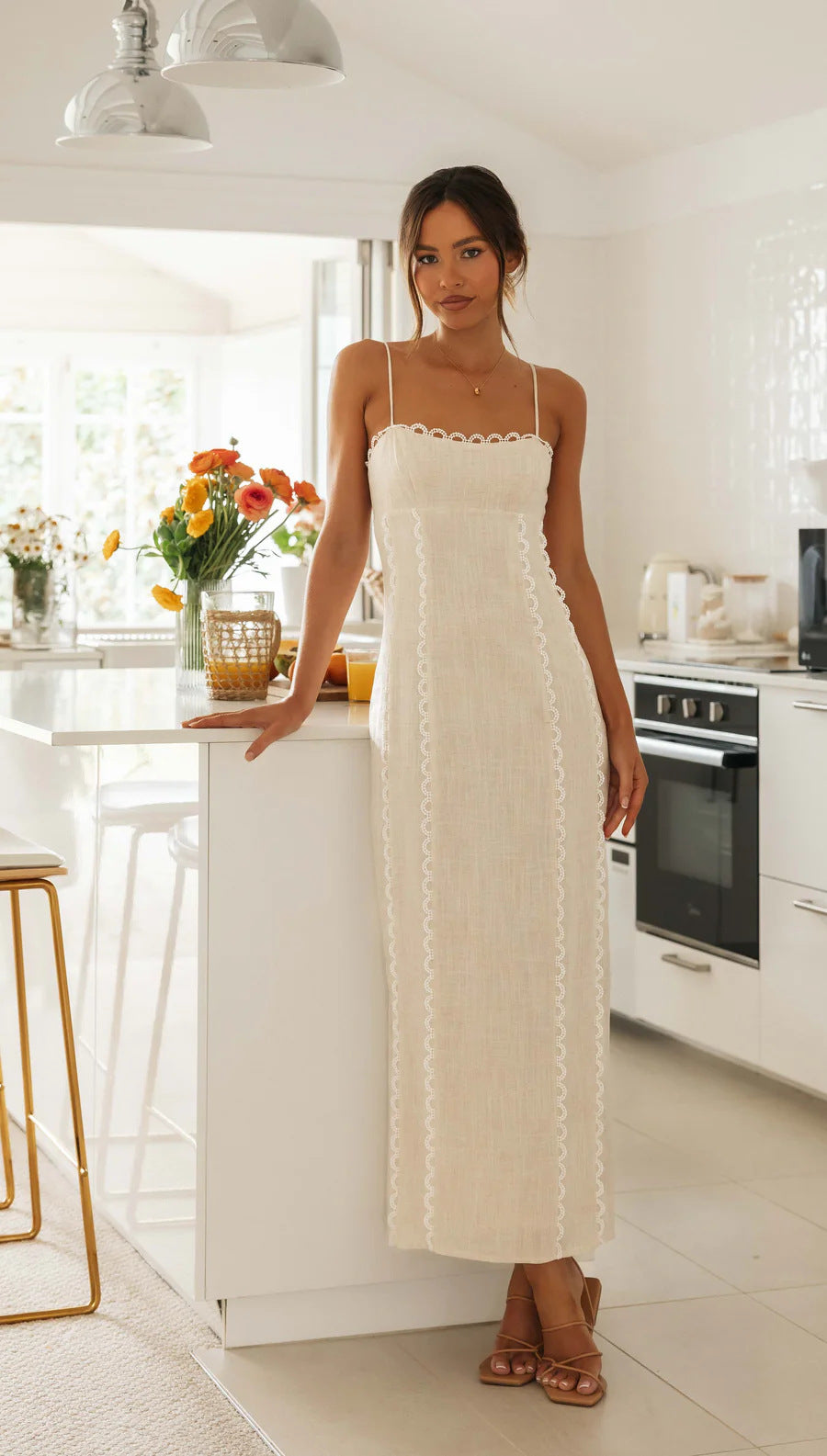Kvinnens elegante maxikjole med fin blonde-detalle og tynne stropper