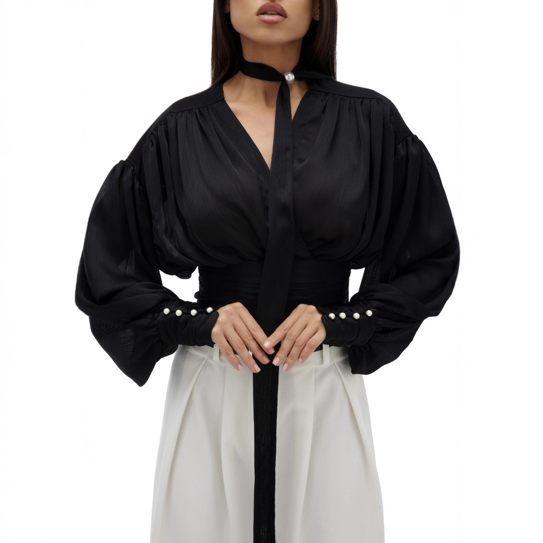 Kvinnebluse med voluminøse ermer og elegante perleknapper Skjora