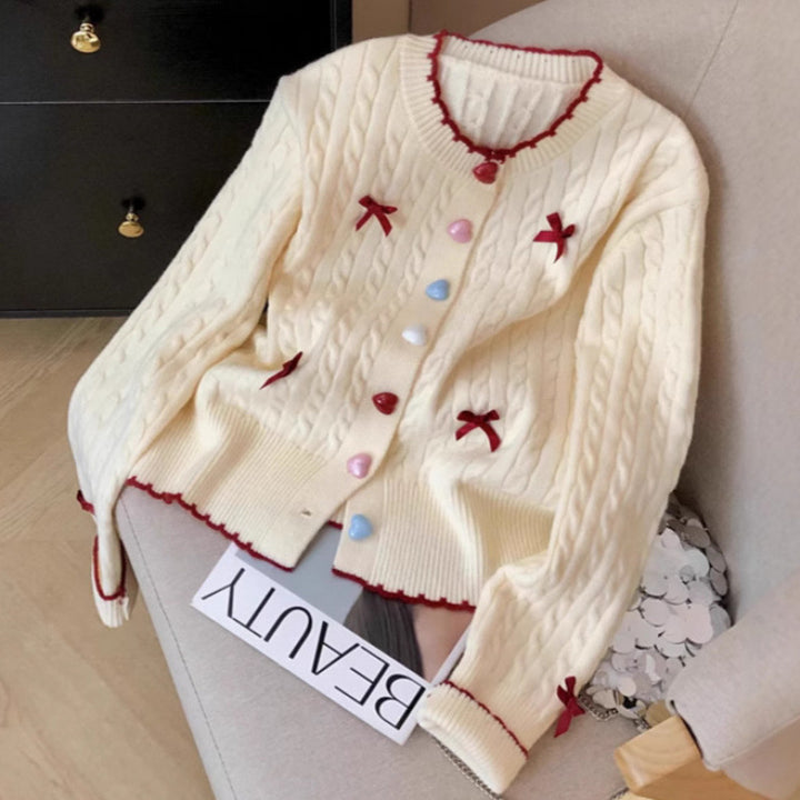 Kvinnens chunky strikket cardigan med lekne knappdetaljer og sløyfer