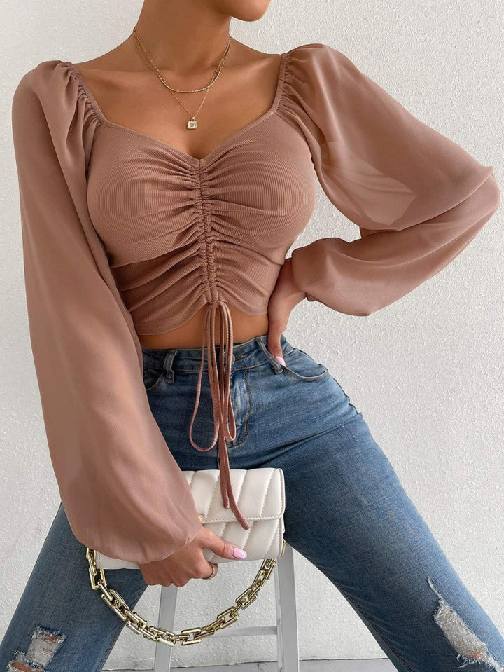 Dame Crop-Top med strukturert kropp og elegante pufferm. Skjora