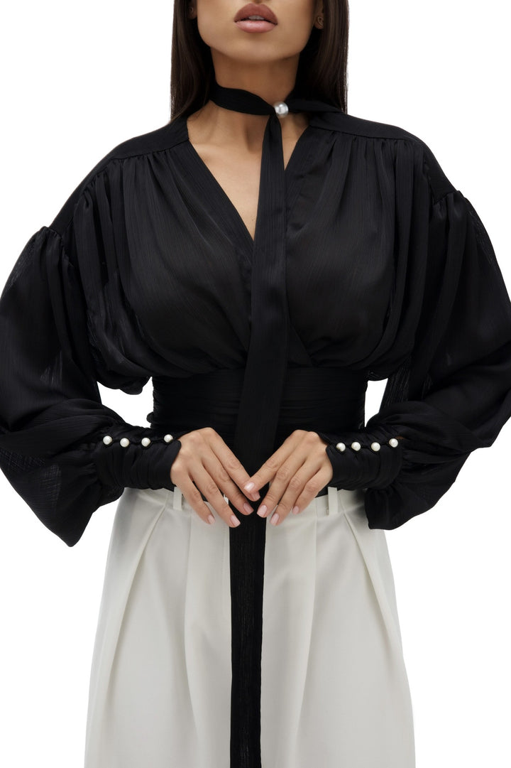 Kvinnebluse med voluminøse ermer og elegante perleknapper Skjora