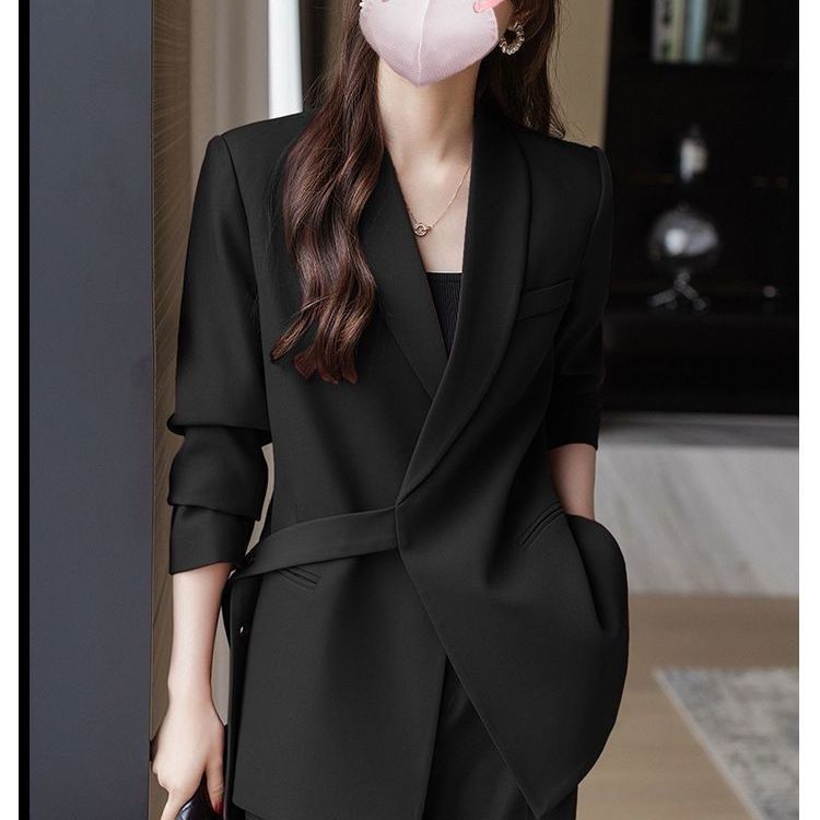 Kvinnens moderne blazer med asymmetrisk snitt og midjebelte Skjora