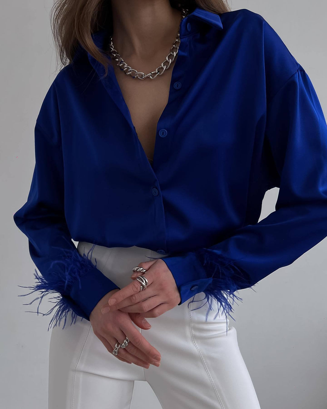 Damebluse med fargerike fjær og elegant snitt Skjora