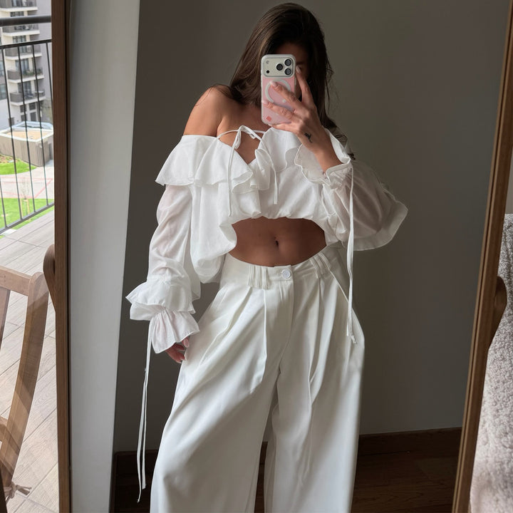 Damebluse med voluminøse volangdetaljer og kapteinsærmer