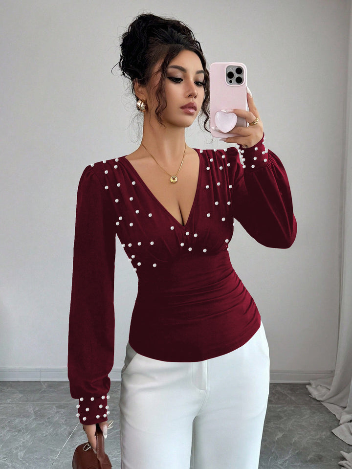 Kvinnes elegant bluse med V-hals og dekorasjon Skjora